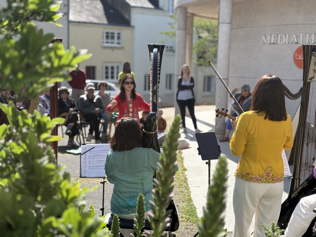 Katryna Tan leads the performers of the Rave Harps Mosaic Ensemble
